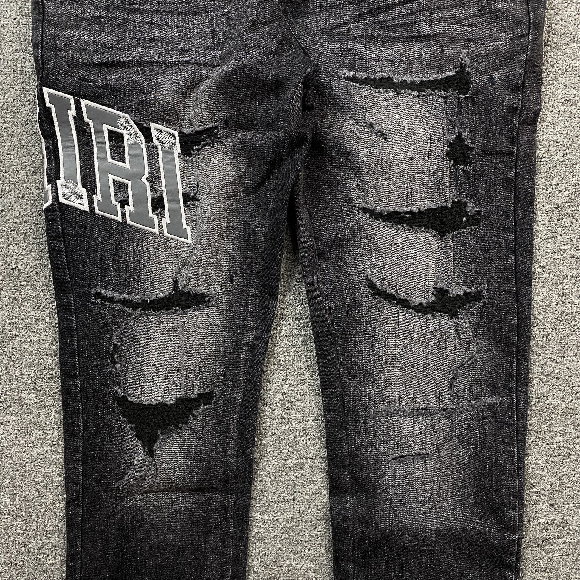 AMIRI VARSITY LOGO REPAIR JEANS
